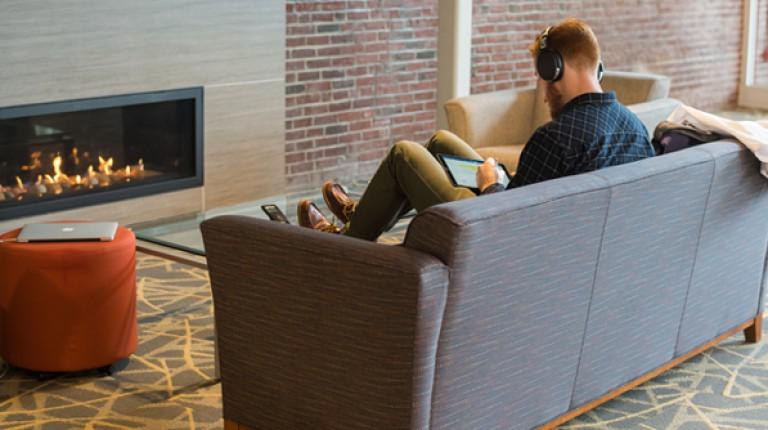 A graduate student studying by a fireplace in Innovation Hall