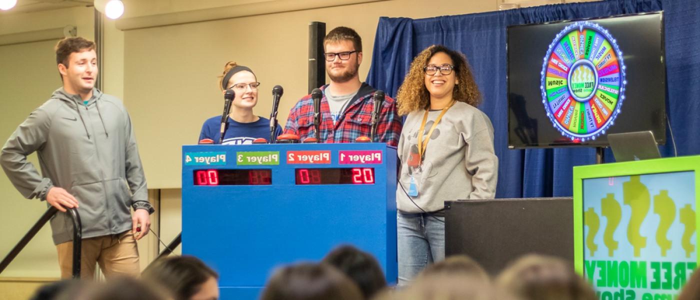 Four students on stage leading a game night